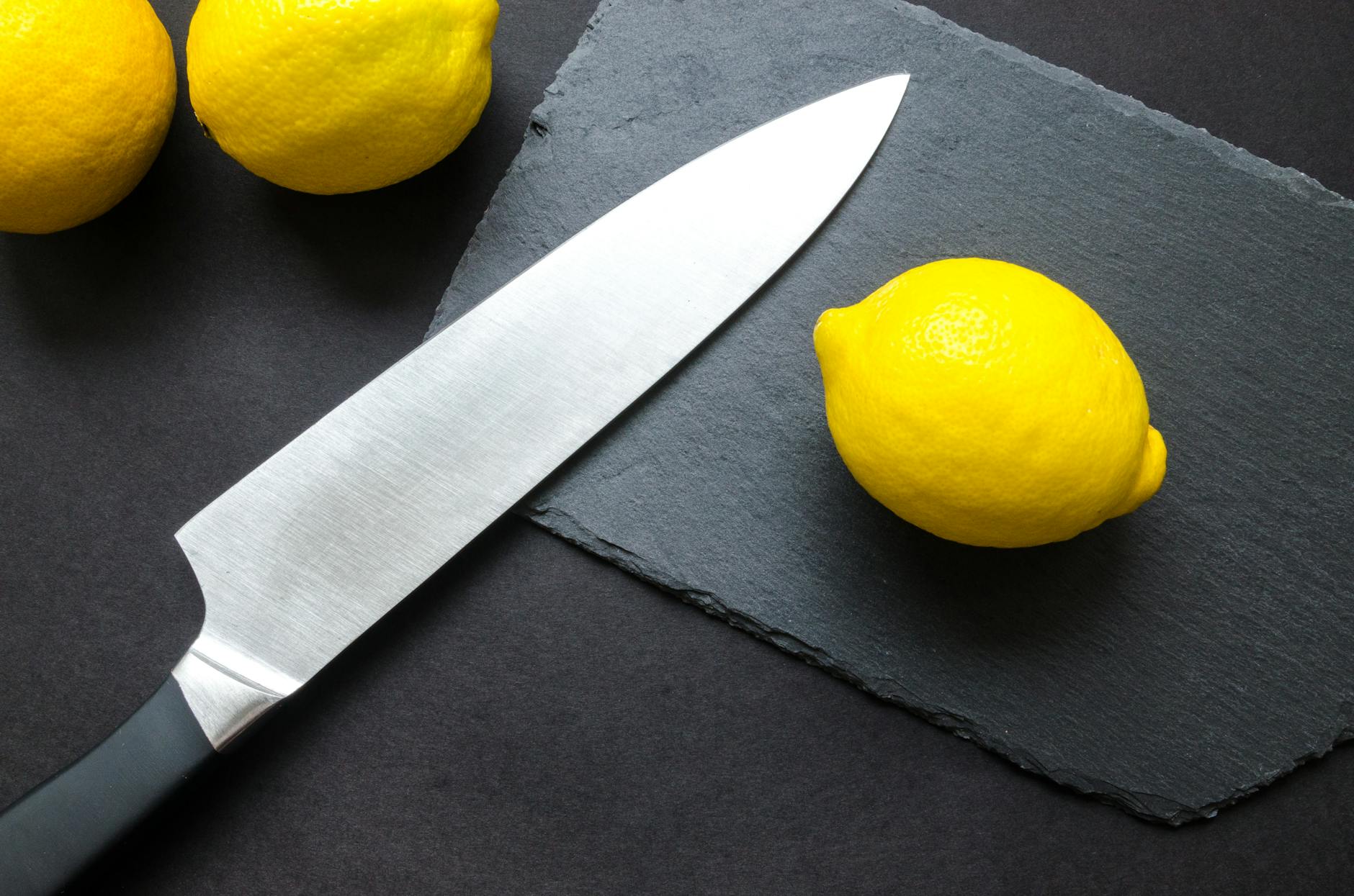 photography of lemon near kitchen knife